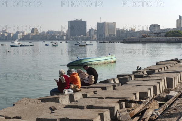 Alexandria, Egypt. December 1st 2022 People on concrete blocks positioned as a defence against