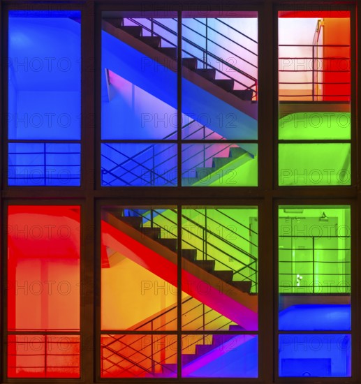 View through the windows of a brightly lit staircase. Frankfurter Mainova AG building, city center,
