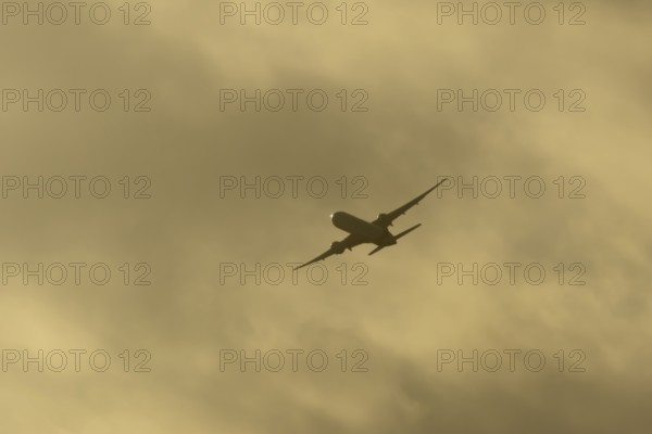 Commercial passenger airliner jet aircraft in flight at sunset at London Stansted airport, Essex,