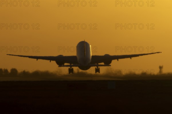 Boeing 777 A7-BFL commercial jet aircraft of Qatar cargo taking off in flight silhouette at sunset
