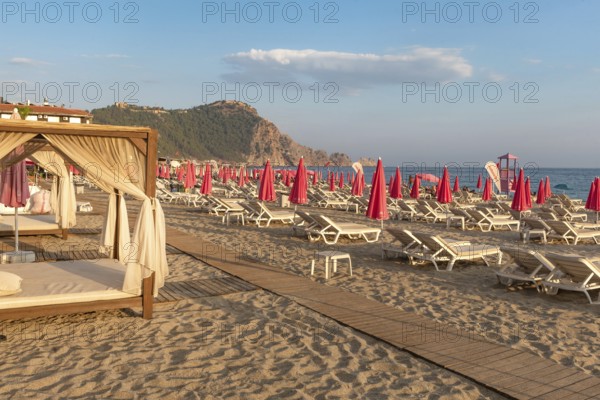 Alanya, Turkey. July 9th 2024 Sunbeds and pink sunshades on Cleopatra Beach in the Turkish holiday