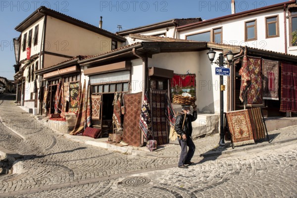 Ankara, Turkey. November 17th 2020 Traditional Turkish Simit seller walking past Antique carpet