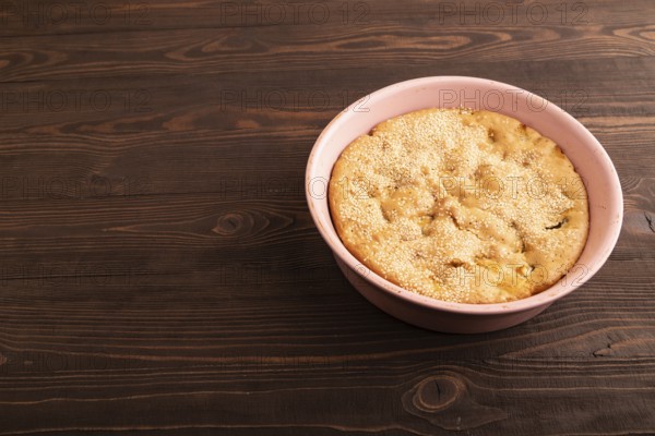 Apple Charlotte cake in baking dish on brown wooden background, top view, flat lay, close up
