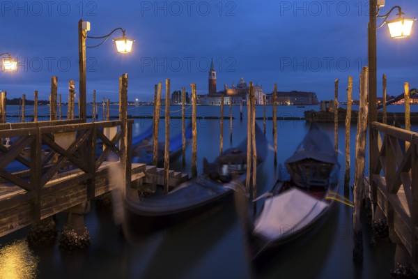 Nighttime atmosphere with moving gondolas, San Georgio Maggiore in the back, Guidecca Island on the