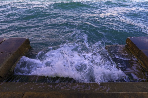 Waves on a staircase, announcement of the Aqua Alta in Venice. Guidecca, Venice, Italy