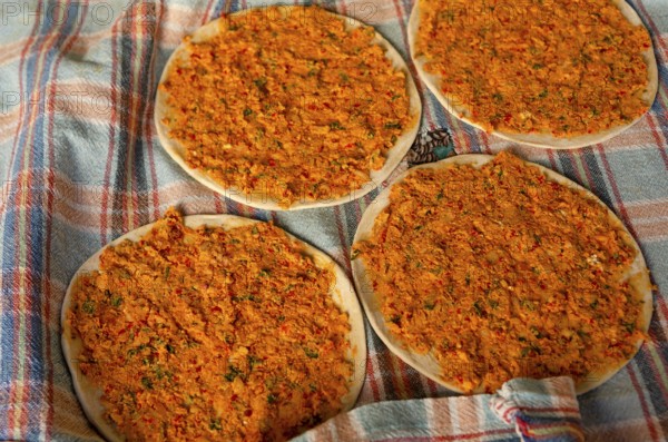 Traditional Turkish Biberli Ekmek Flat bread with red pepper paste being prepared before cooking in