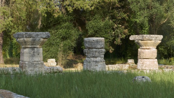 Three stone column remains in a green area, Archaeological Site, Ancient Olympia, Olympia,