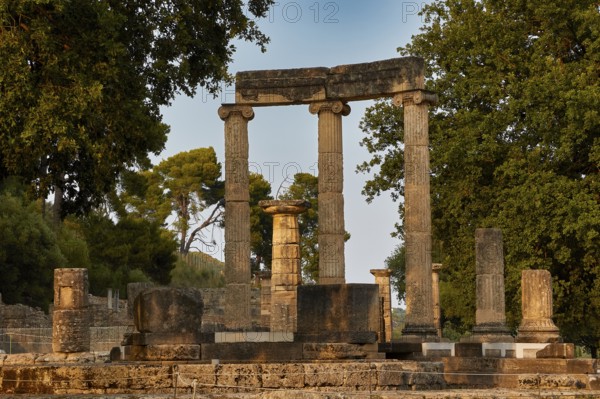 Philippeion, Sublime ancient columns in an archaeological site with trees in the background,