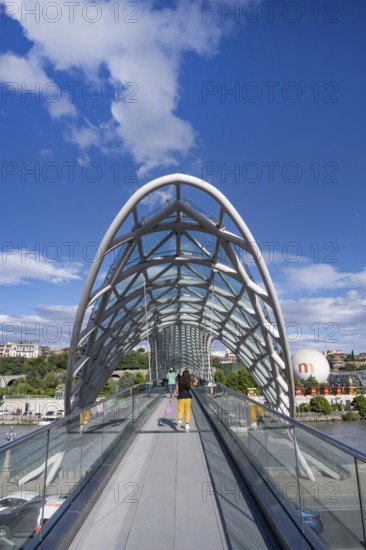 Tbilisi, Georgia. September 12th 2025 Tourists cross The Bridge of Peace over the Kura River also