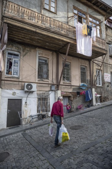 Tbilisi, Georgia. September 12th 2025 An old man walks through the cobbled narrow streets past