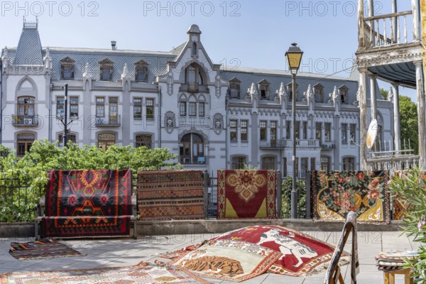 Tbilisi, Georgia. August 5th 2025. Traditional patterned rugs and carpets for sale outside a shop