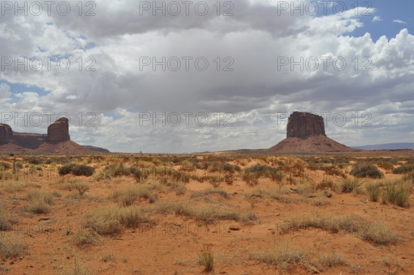 Wide dry plain with isolated rocks under dramatic skies, Monument Valley, Navajo Tribal Park,