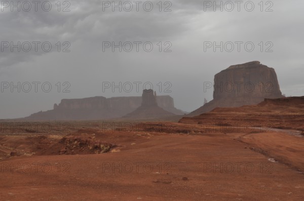 Impressive mesas under a cloudy sky in a vast desert landscape after a severe thunderstorm,