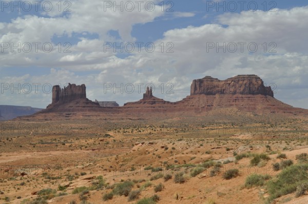 Impressive rock formations rise in a sunny desert landscape, Monument Valley, Navajo Tribal Park,