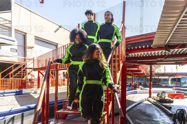 Group of diverse friends wearing racing suits and feeling excited, walking down stairs together at