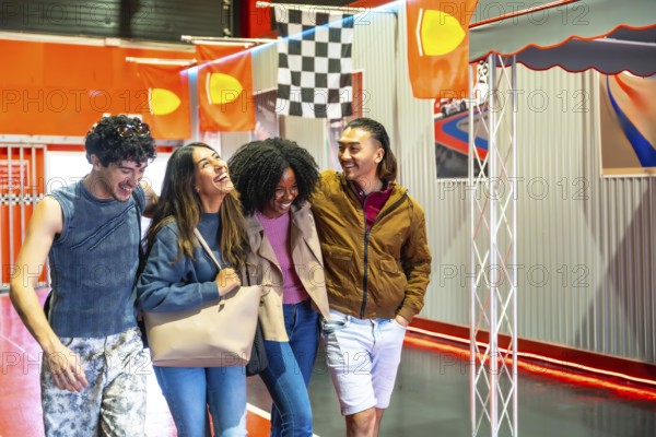 Diverse group of smiling young adult friends having fun and embracing casually while walking