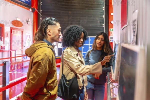 Diverse friends interacting with a digital touchscreen display, selecting racing karts for a fun