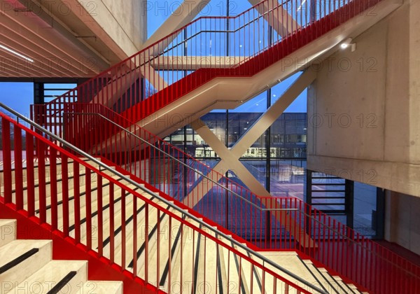 Staircase with signal red color scheme in seminar building H of Bochum University in the evening