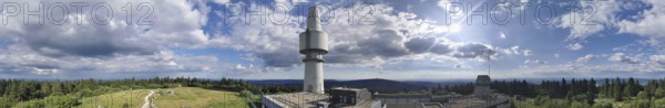 Panoramic view of the Schneeberg with the Backöfele, a high tower under a sunny sky full of clouds,
