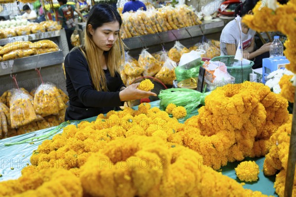 Bangkok, Thailand. March 2rd 2025. A Thai woman making traditional flower garlands at Pak khlong