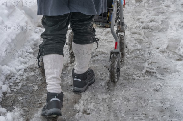 Detail, elderly man pushes his walker through slush in the city, Nuremberg, Middle Franconia,
