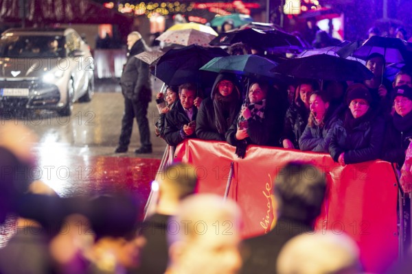 Fans in the rain with umbrellas at the opening of the Berlinale at the Theater am Potsdamer Platz