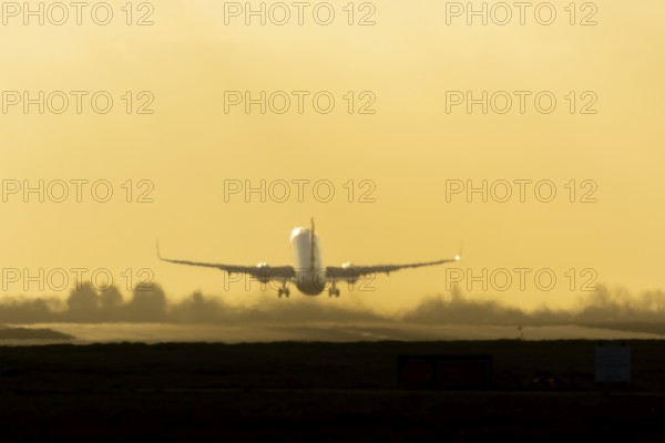 Airbus commercial passenger airliner jet aircraft taking off in flight at sunset at London Stansted