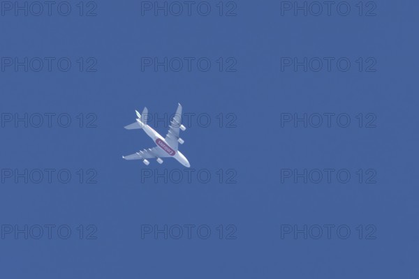 Airbus A380 commercial passenger airliner jet aircraft of Emirates airlines flying in a blue sky,