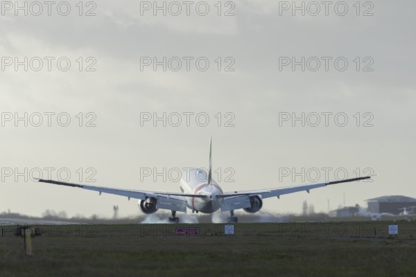 Boeing 777 commercial passenger airliner jet aircraft of Emirates airways landing on the runway at