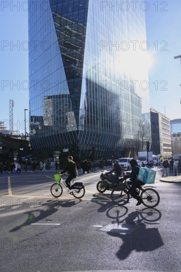 London, UK. January 31st 2025. A Lime bike and delivery rider cycle through a busy traffic