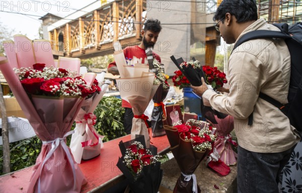 Customers browse red roses and other flowers at a roadside flower shop on Valentine's Day, in