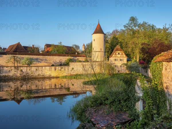 Digestive tower with park guard house on the city wall in morning light, reflection in the