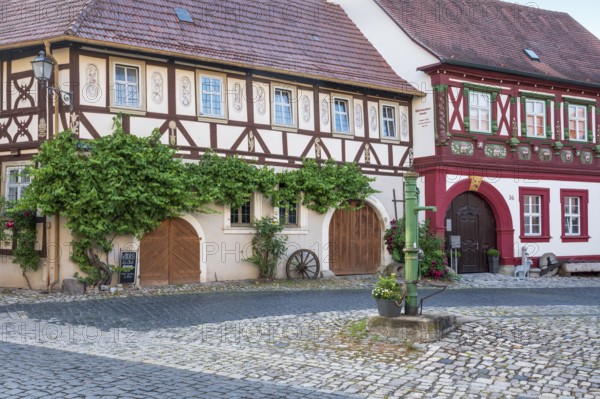 Street in the historic old town with half-timbered houses, cobblestones and hand pump, Alte