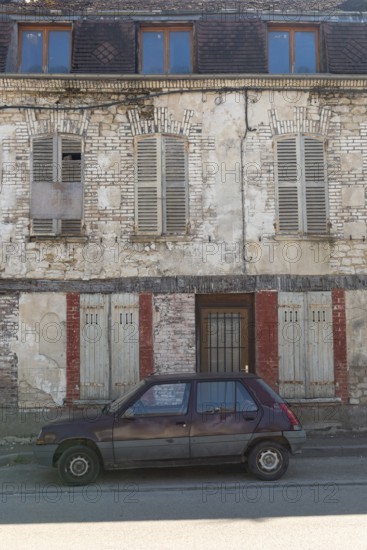 A popular old French car parked outside a typical rural French house in a countryside village in