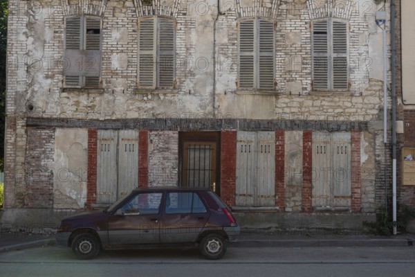 A popular old French car parked outside a typical rural French house in a countryside village in