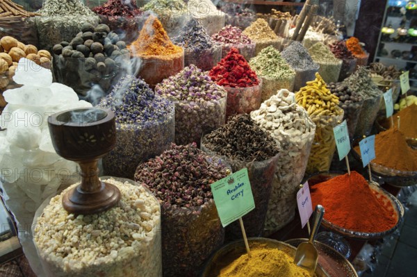 Dubai, United Arab Emirates. July 1st 2019 Incense burning alongside coloured spices for sale in