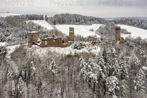 Medieval castle ruins in a snowy hilly landscape with forests, The Brandenburg in the Werra Valley