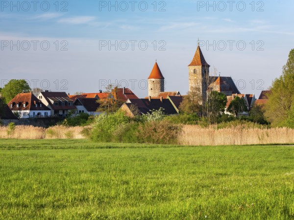 View over a meadow in the Altmühltal valley to the historic old town of Ornbau in the evening