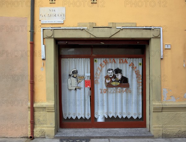 Italy, village of Brescello, advertisement for Pizzeria Pasquale, with a picture of Don Camillo and