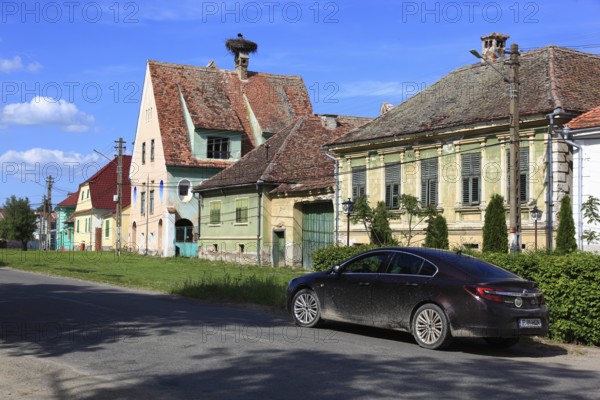 Typical rural houses in the old village of Dealu Frumos, Schönberg, in front of that an Opel