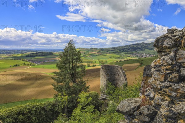 Ruins in front of a wide view of fields and hills under a cloudy blue sky, Mägdeberg Castle Ruins,