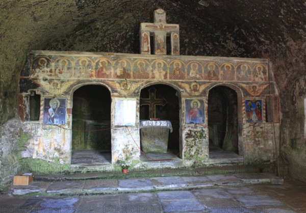 Corbii de Piatra rock monastery, stone ravens carved into a massive, 30-meter high sandstone wall,