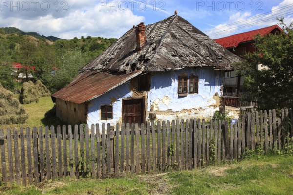 Traditional Romanian farmhouse that is in a dilapidated or abandoned state. The eye-catching light
