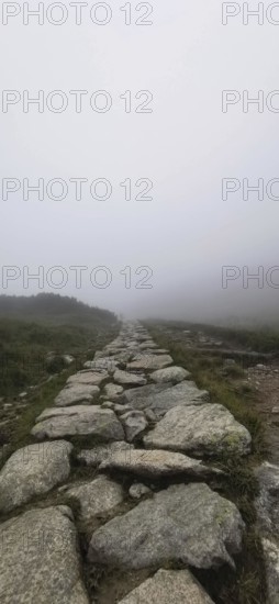 Rocky trail through misty landscape with harsh, mystical ambiance, Zakopane, hiking to Kasprowy