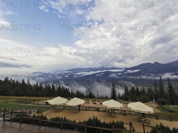 Mountain panorama with clouds, conifers and leisure area, huts and wide sky, Gubalowka, Zakopane,