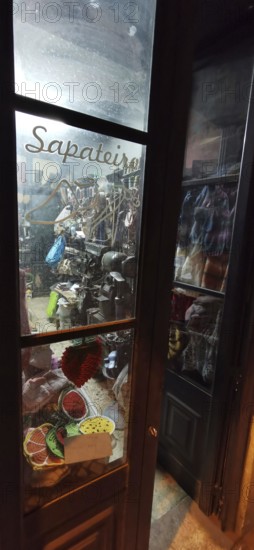 Shoemaker's shop window with traditional tools and materials at night, Lisbon