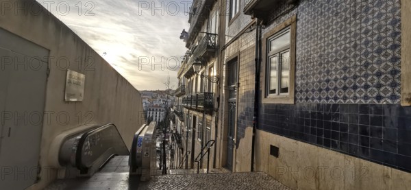 Evening atmosphere on a staircase with a view of decorated house facades and tiles, Lisbon,