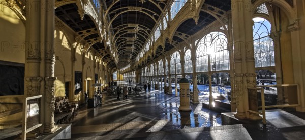 Large, sun-drenched interior of a historic hall with arched windows and columns, wellness,