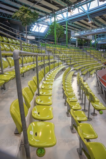 Green seats in a modern sports hall, arranged in rows along a grandstand, Sindelfingen Glass