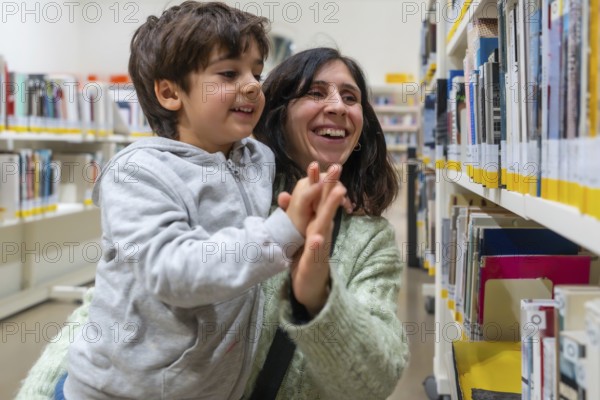 Parent and young child are sharing a joyful high five gesture while standing in a brightly lit